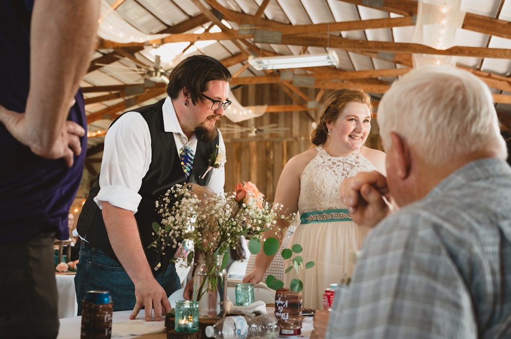 a man standing next to a woman at a table