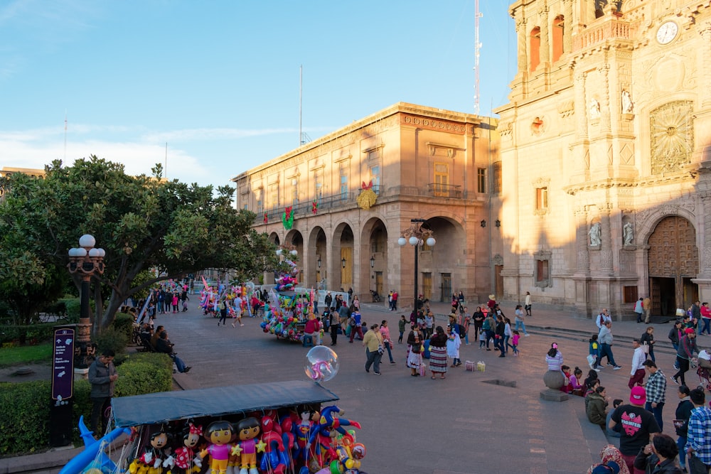 a crowd of people walking around a city square