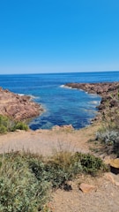 A scenic view of Qingdao’s coastline with clear blue waters and a walking path.