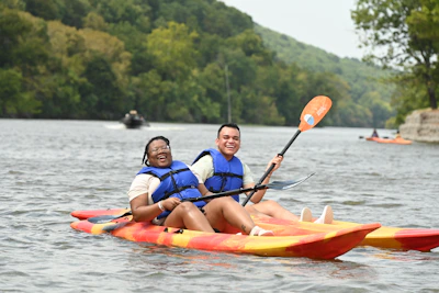 Couple sharing a laugh while kayaking on a crystal-clear river.