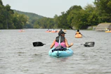 Friends kayaking together on a calm river surrounded by forest.
