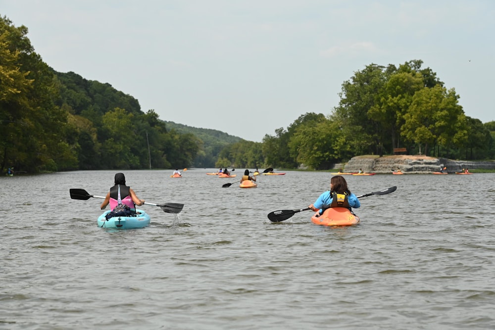 a group of people riding kayaks on top of a lake