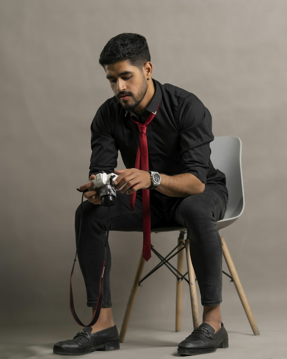 a man sitting on a chair holding a camera