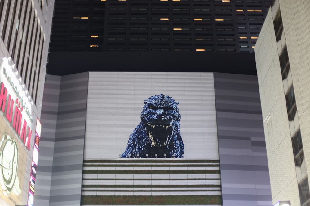 a giant screen of a godzilla on a building