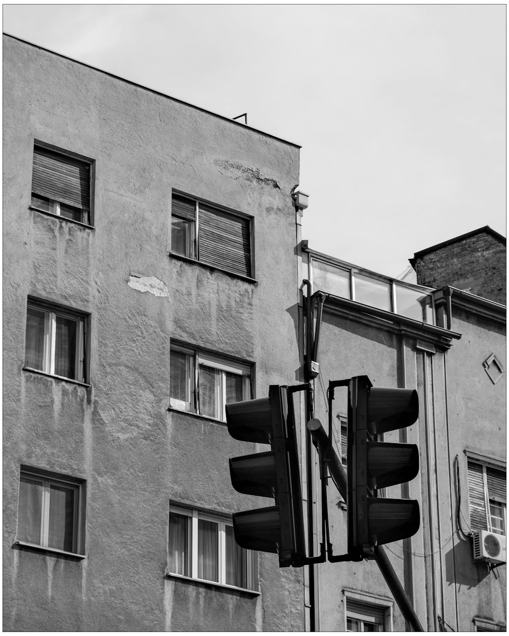 a black and white photo of a traffic light in front of a building