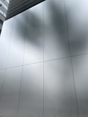Glass panel work on a building facade reflecting the surrounding landscape.