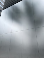 Wide shot of a commercial facade featuring custom aluminum panels with reflective glass.