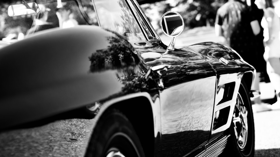 A sparkling clean car under bright sunlight showcasing a reflective surface.