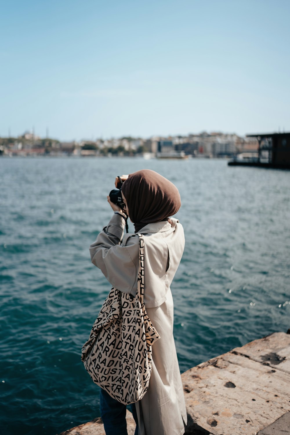 a woman taking a picture of a body of water