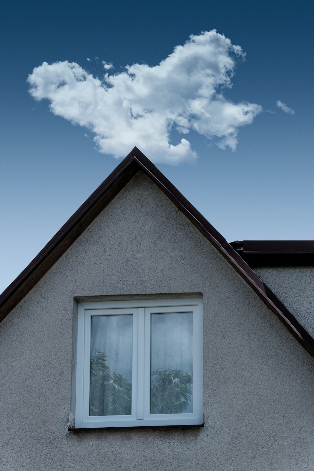 a house with a window and a cloud in the sky