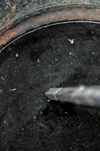 a black pot with a silver handle and a white handle