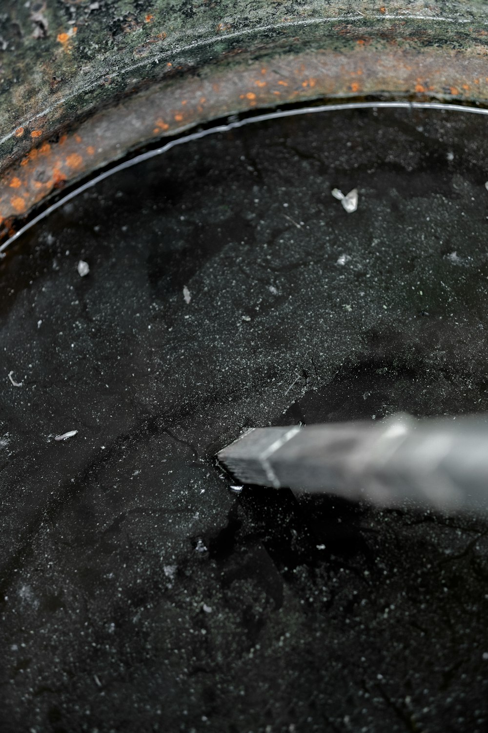 a black pot with a silver handle and a white handle