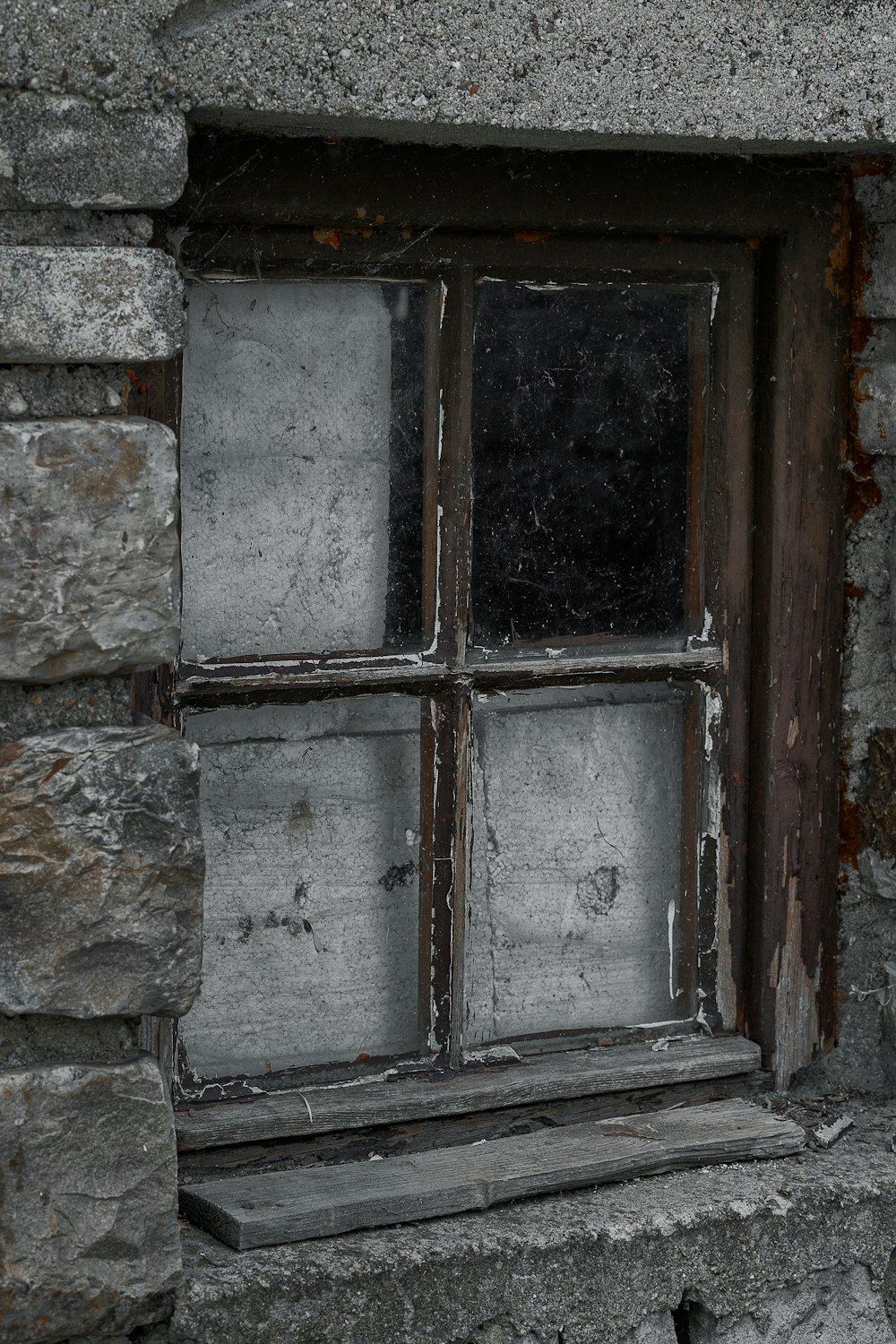 a window in a stone wall with a wooden frame