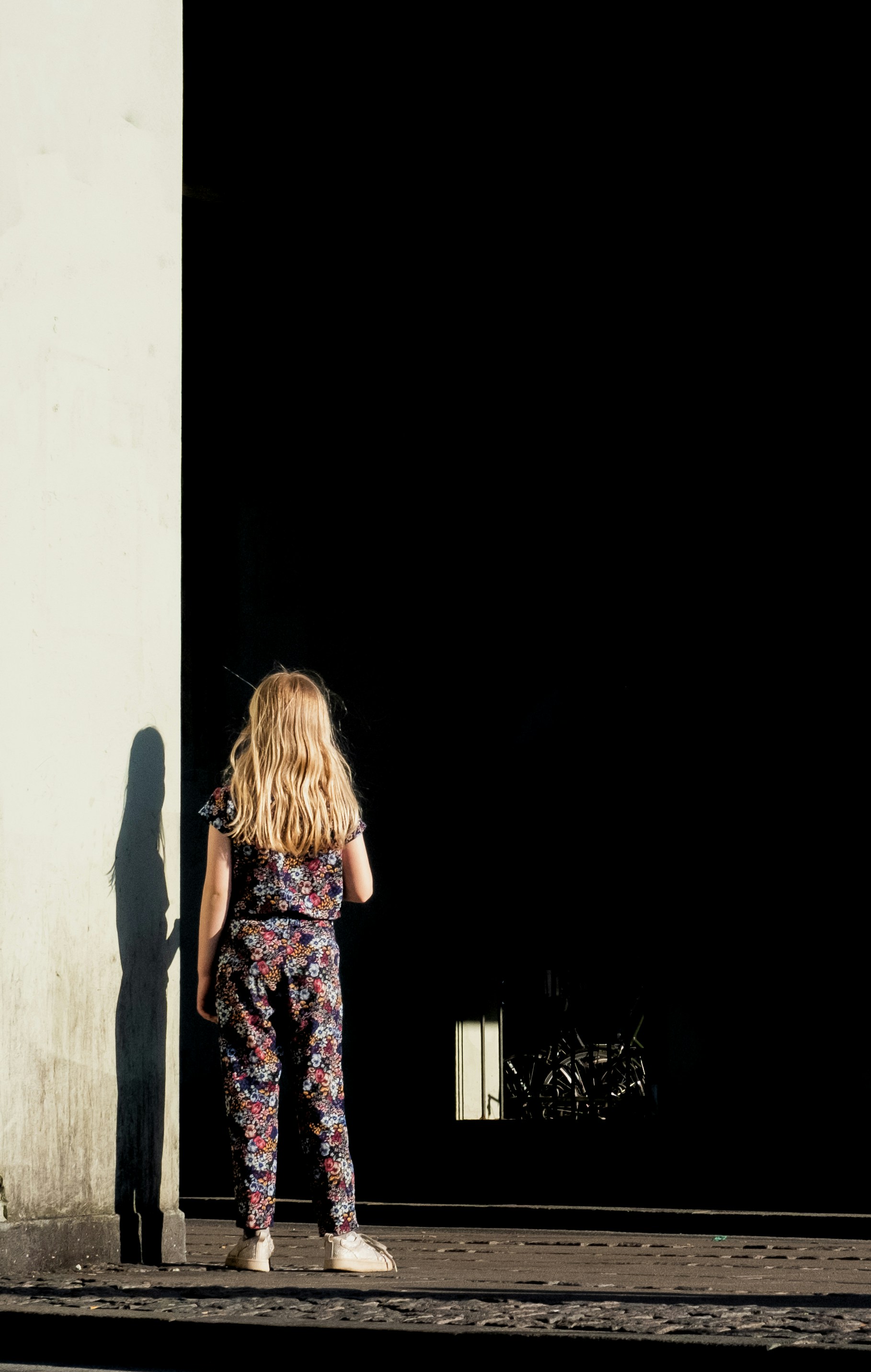 uma menina em pé na frente de um prédio