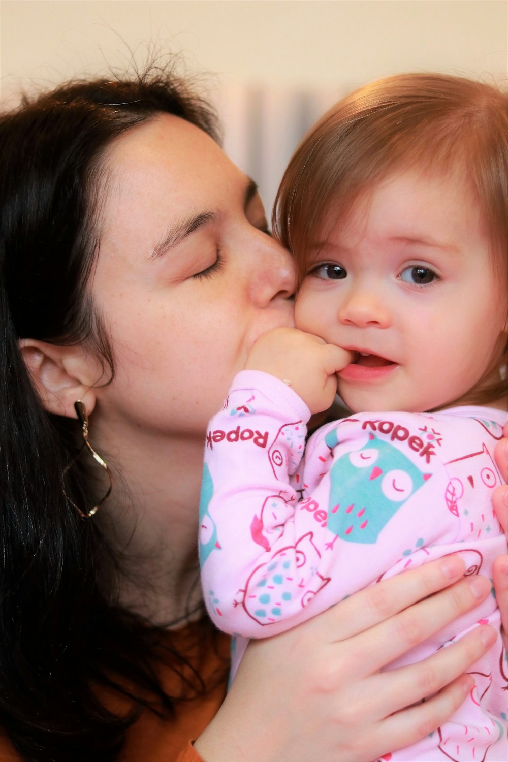 a woman kissing a baby with her mouth open
