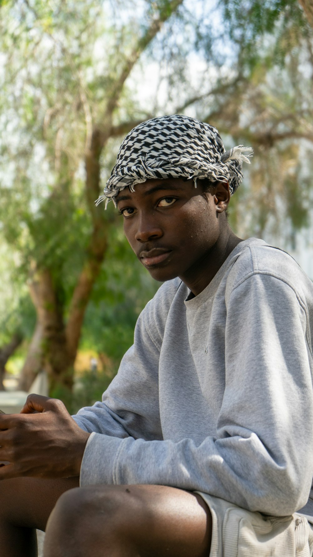 a man sitting on a bench with a cell phone in his hand