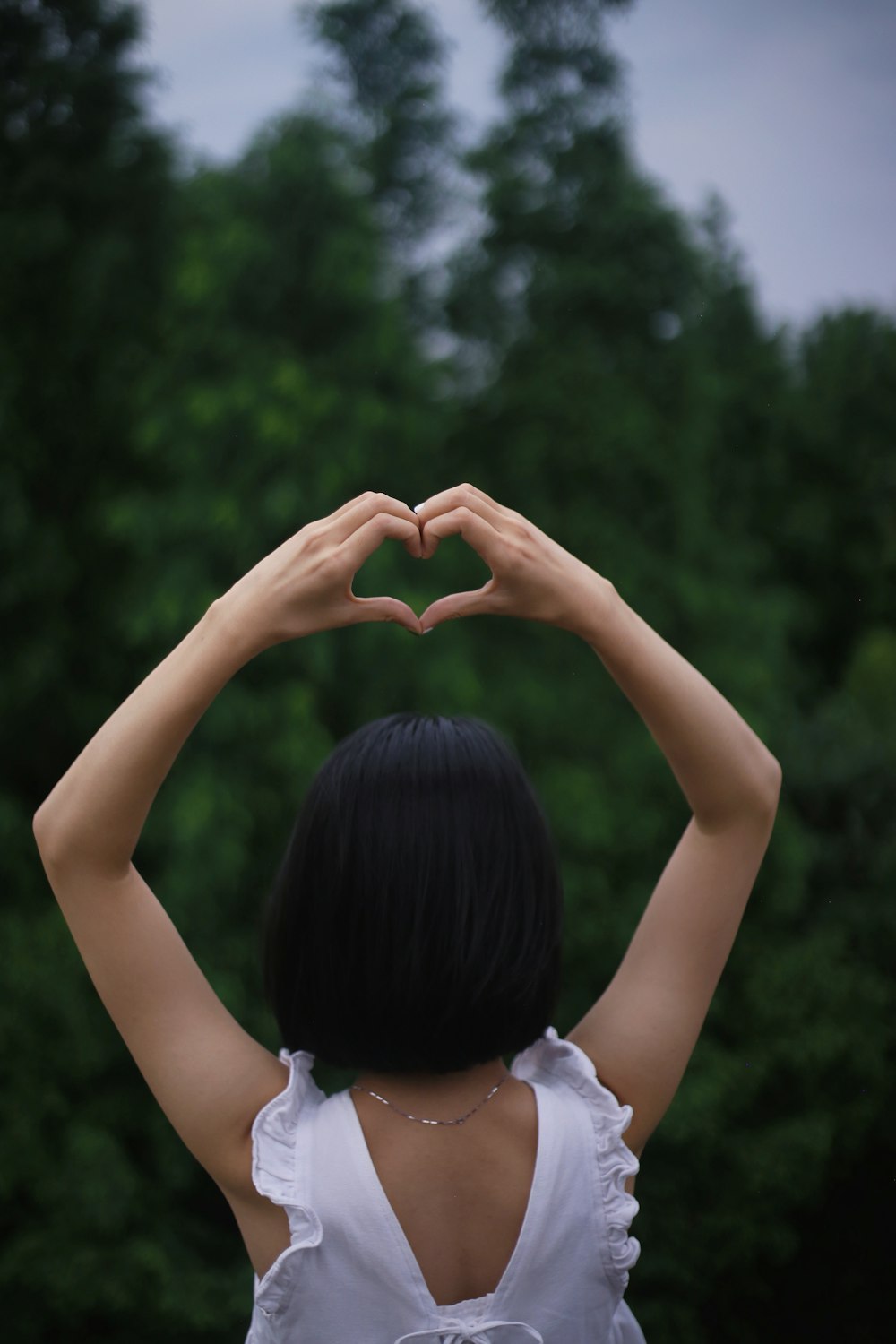 a woman making a heart shape with her hands