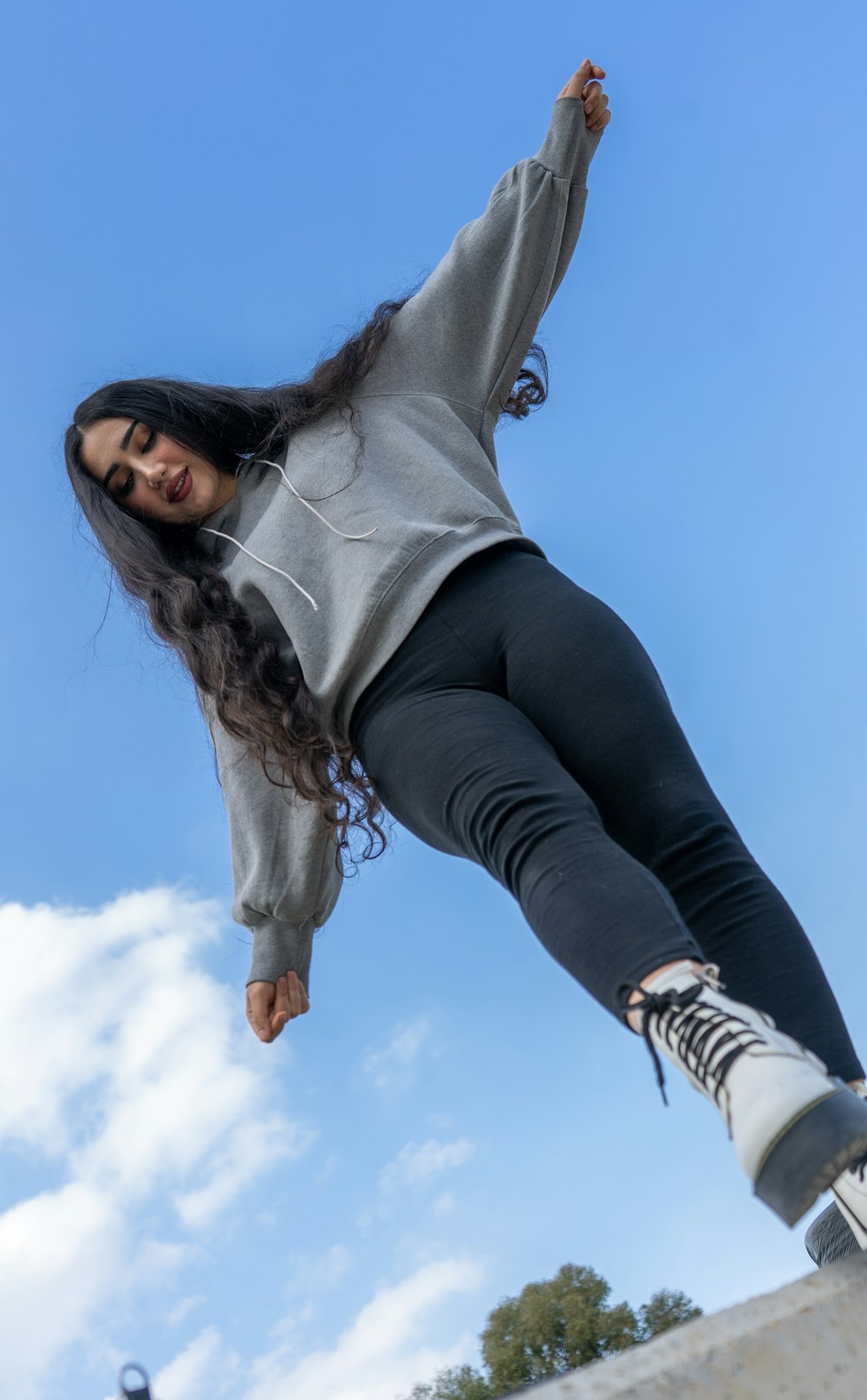 a woman riding a skateboard up the side of a ramp