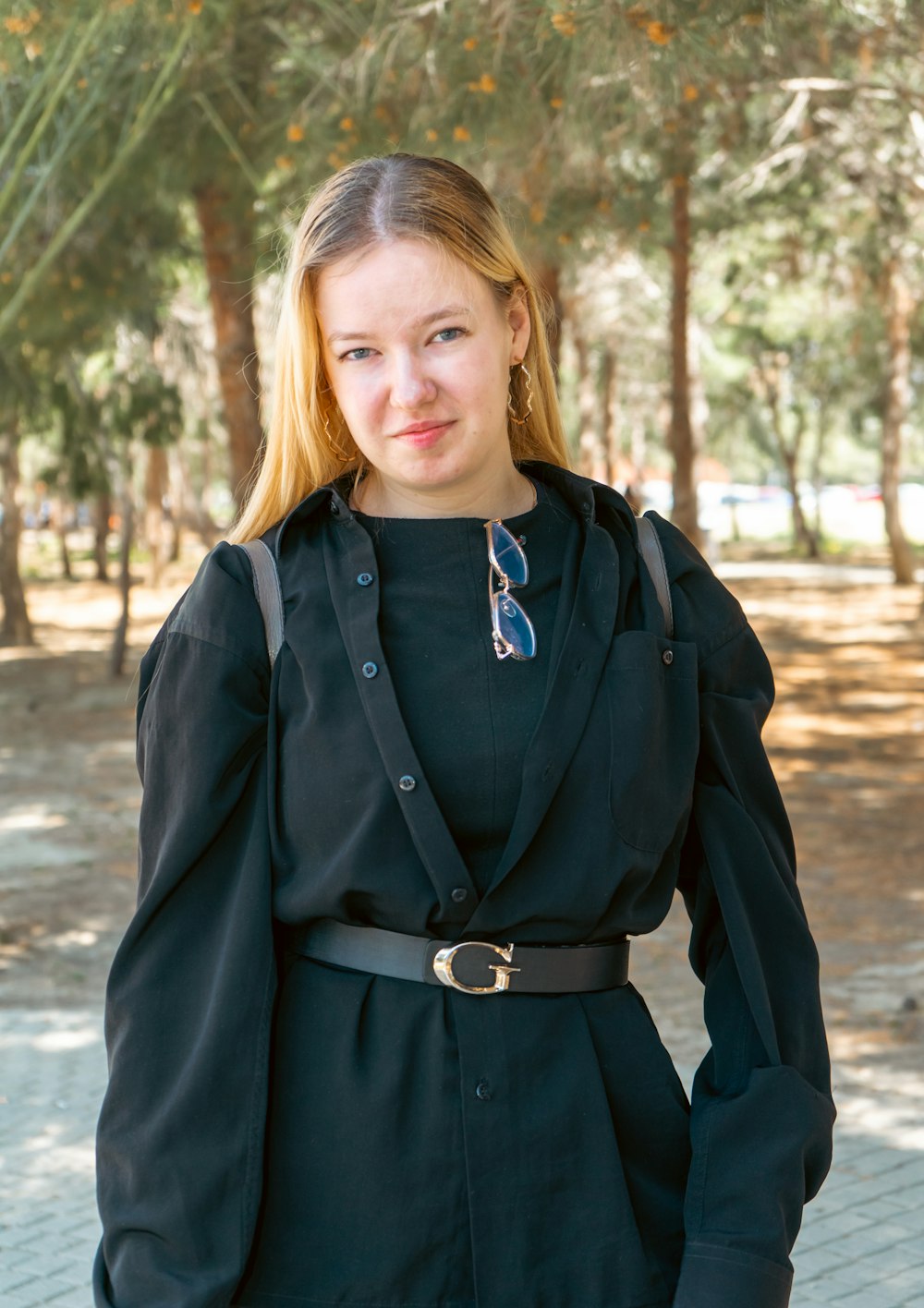 Una mujer con un vestido negro y una chaqueta posando para una foto