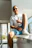 A cheerful man giving a thumbs up in a bright office environment.