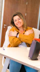 a woman sitting at a table with her arms crossed