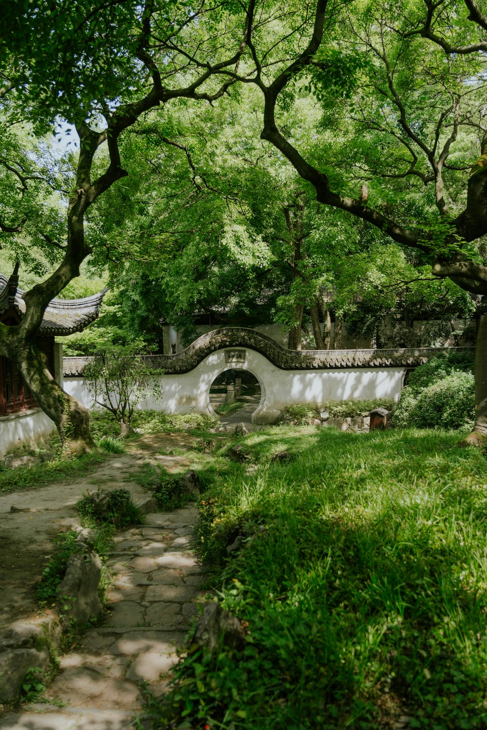 a stone path through a lush green park