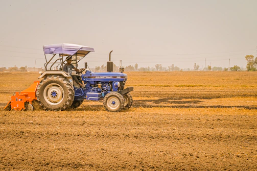 a blue tractor is driving through a field