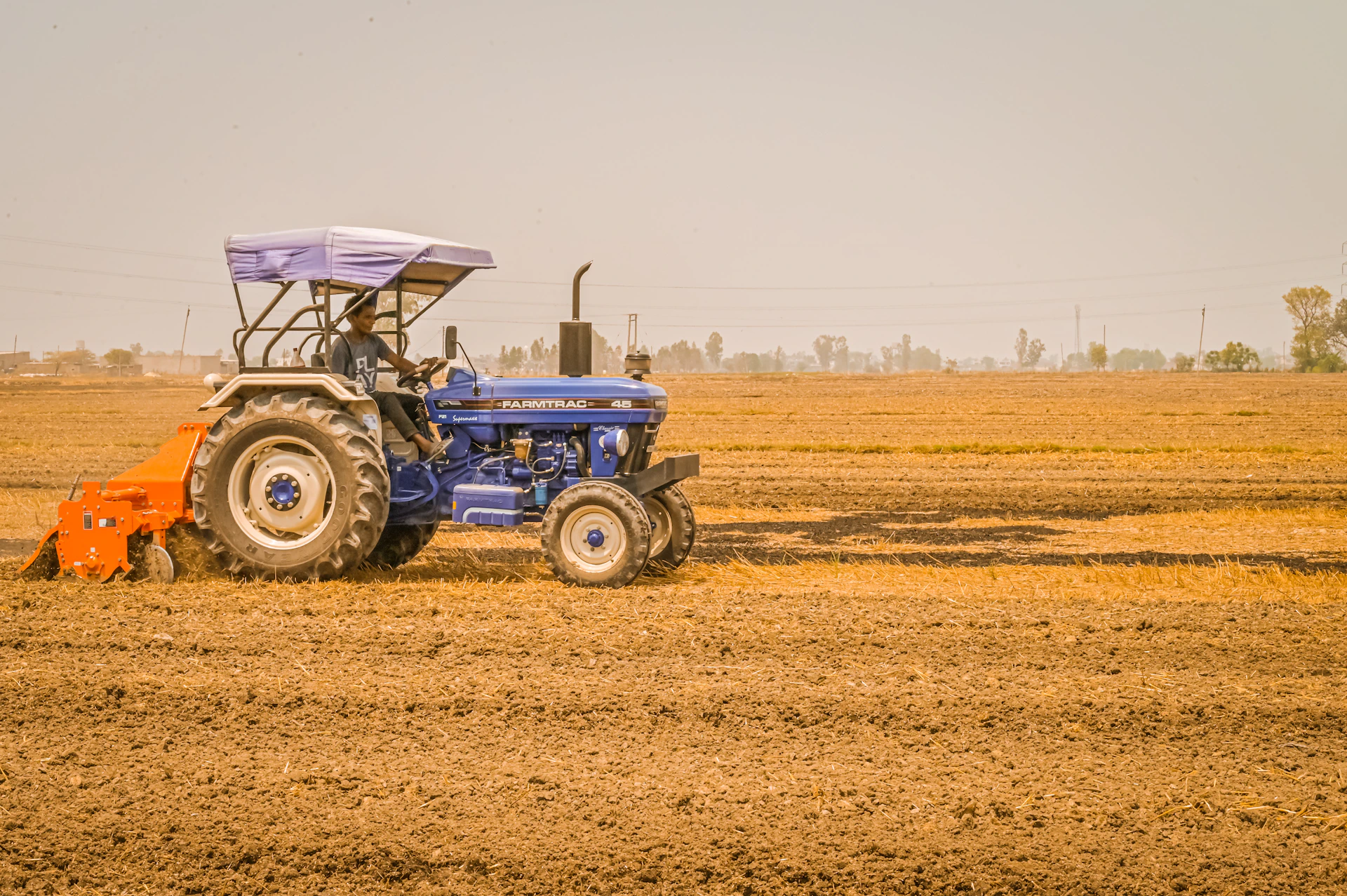 a blue tractor is driving through a field