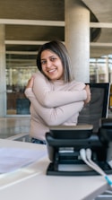 Smiling staff member assisting a client via phone in a modern office.