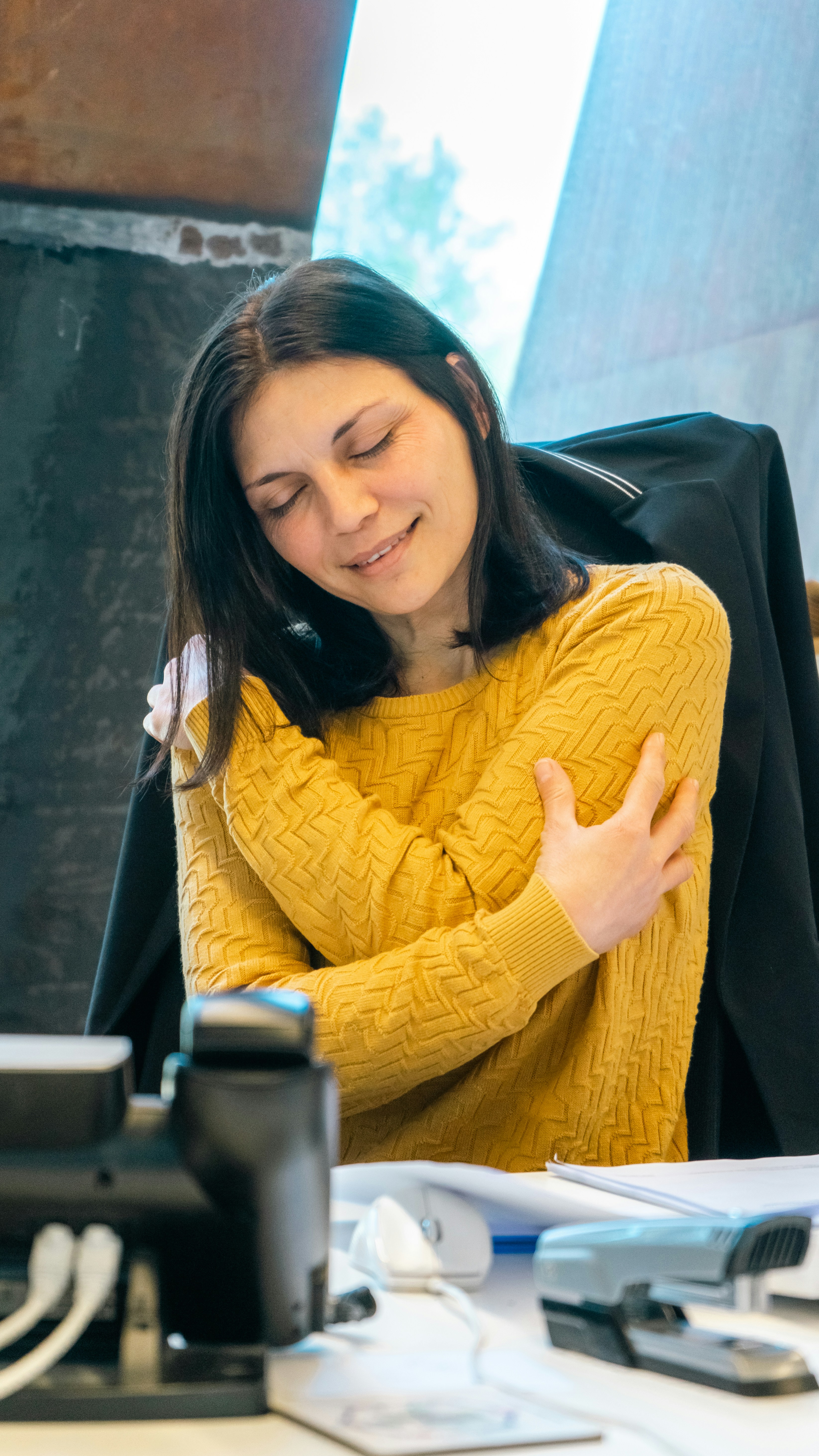 a woman sitting at a table with a laptop computer