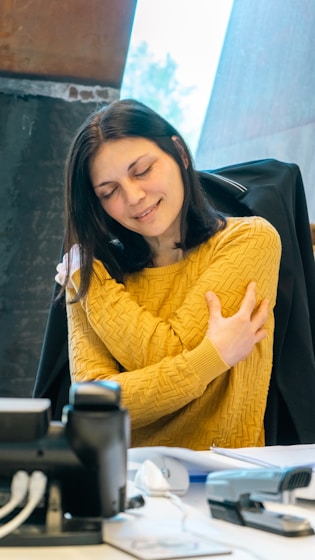 a woman sitting at a table with a laptop computer