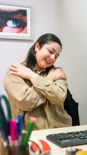 a woman sitting at a desk with her arms crossed