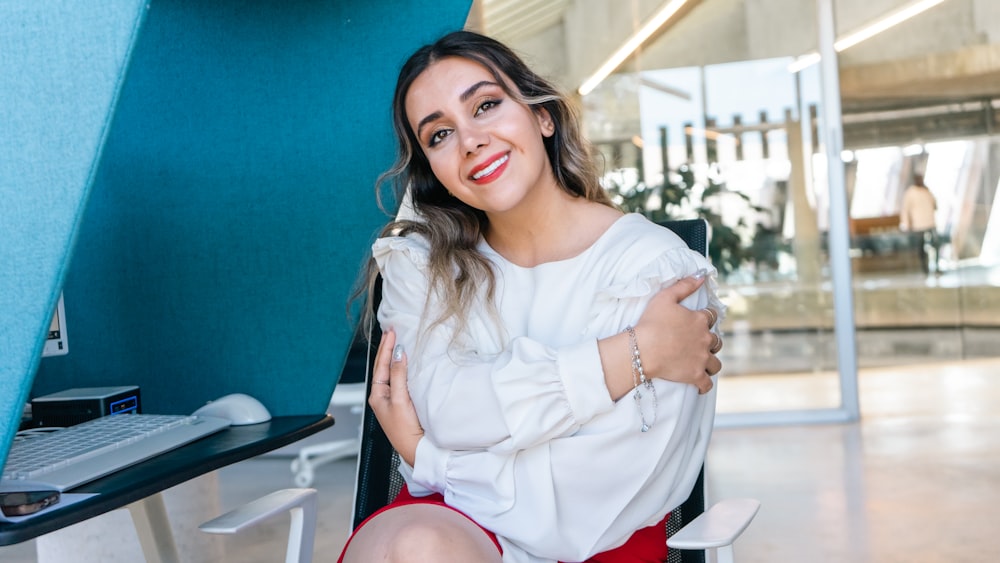 a woman sitting in a chair with her arms crossed