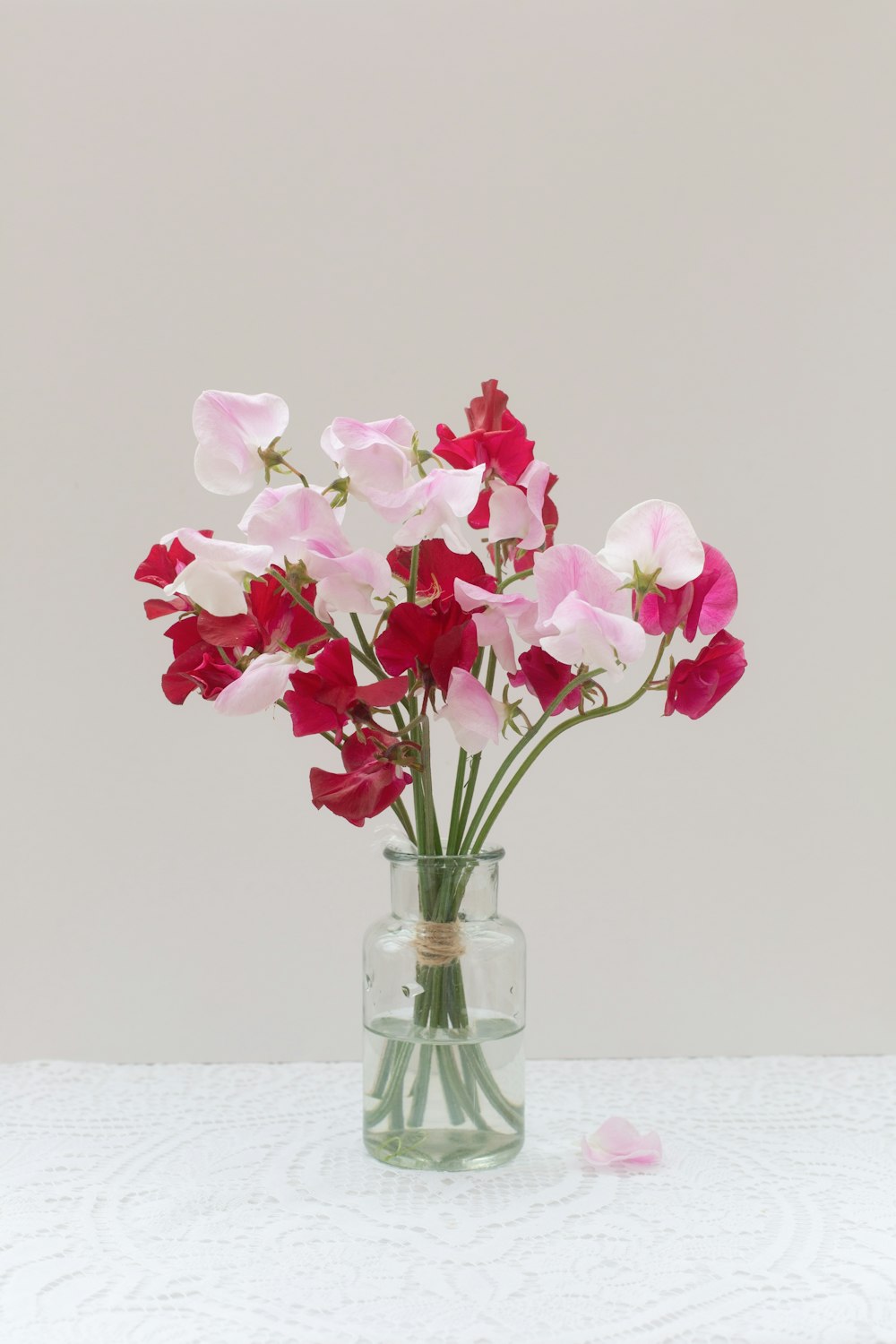 a glass vase filled with pink and white flowers