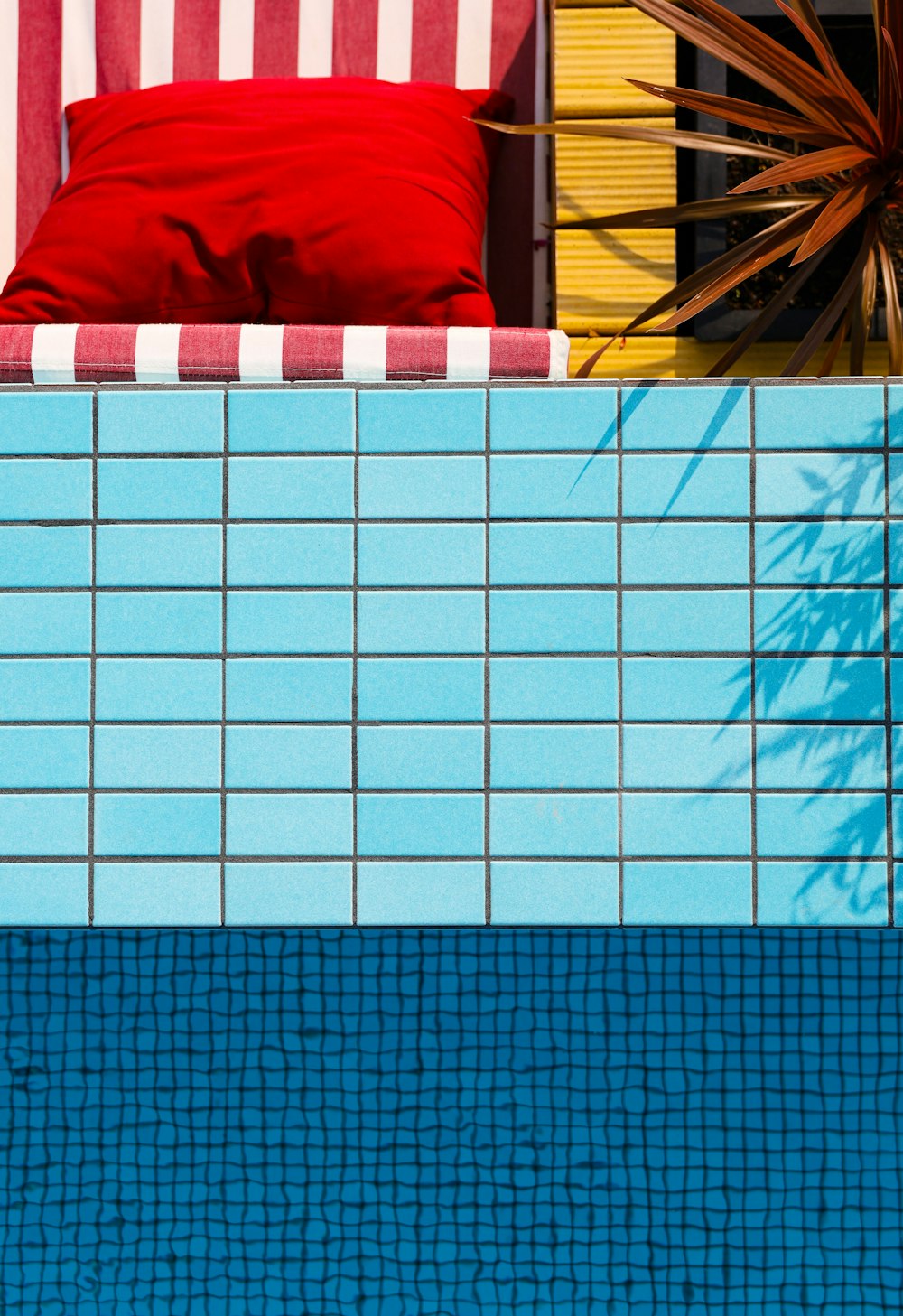 a red pillow sitting on top of a blue swimming pool