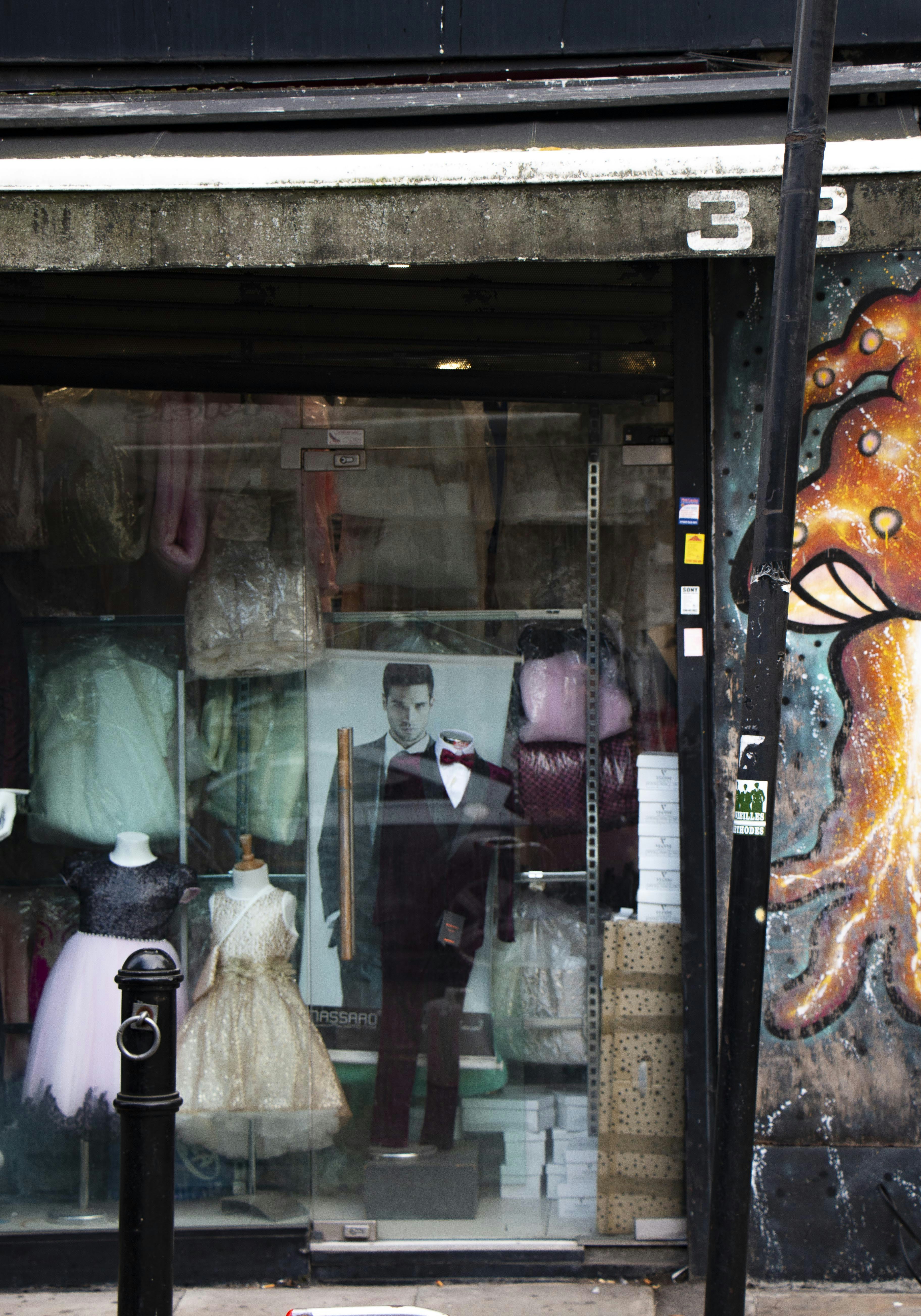 a store front with mannequins and dresses on display