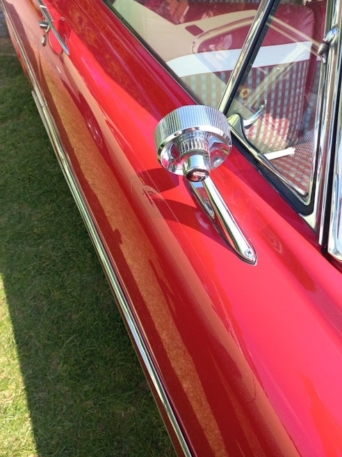 Close-up of a shiny used car ready for sale, showcasing its polished exterior under natural light.