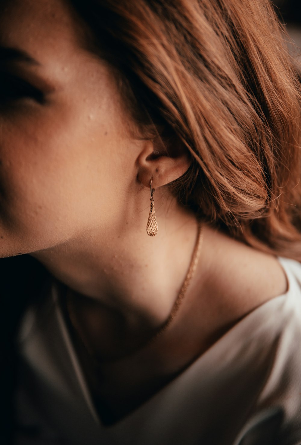 a close up of a person wearing a pair of earrings