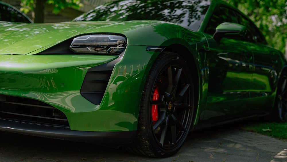 a green sports car parked in a driveway