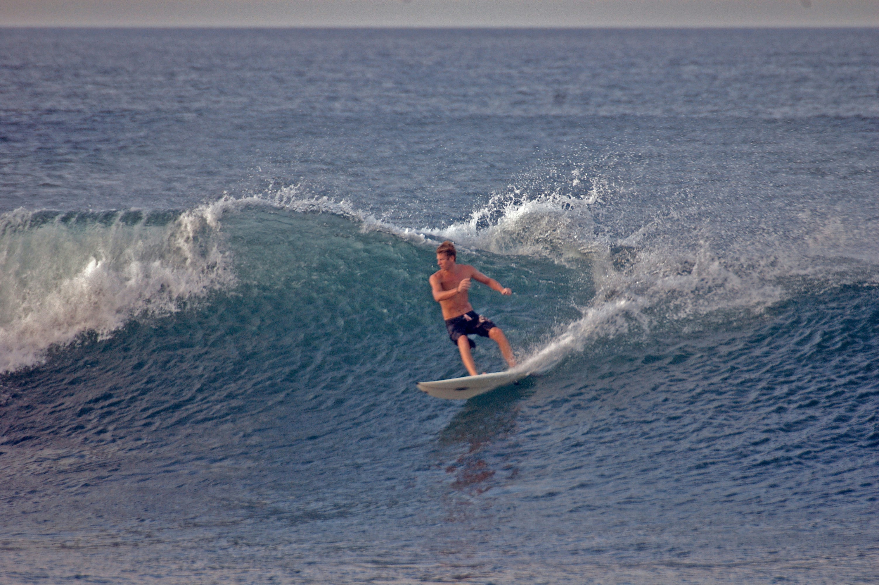 a man riding a wave on top of a surfboard