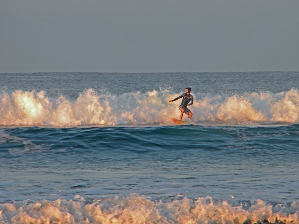 a man riding a wave on top of a surfboard