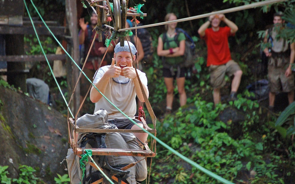 a man riding a zip line in the jungle