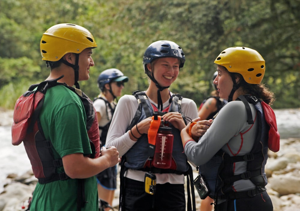 a group of people standing next to each other near a river