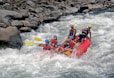 a group of people riding a raft down a river