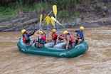 a group of people riding on the back of a raft down a river