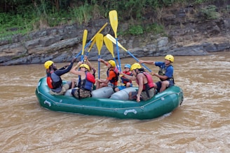 a group of people riding on the back of a raft down a river