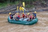 a group of people riding on the back of a raft down a river