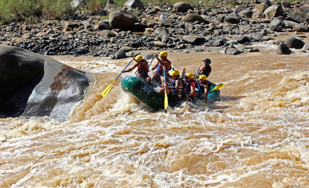 a group of people riding on the back of a raft down a river