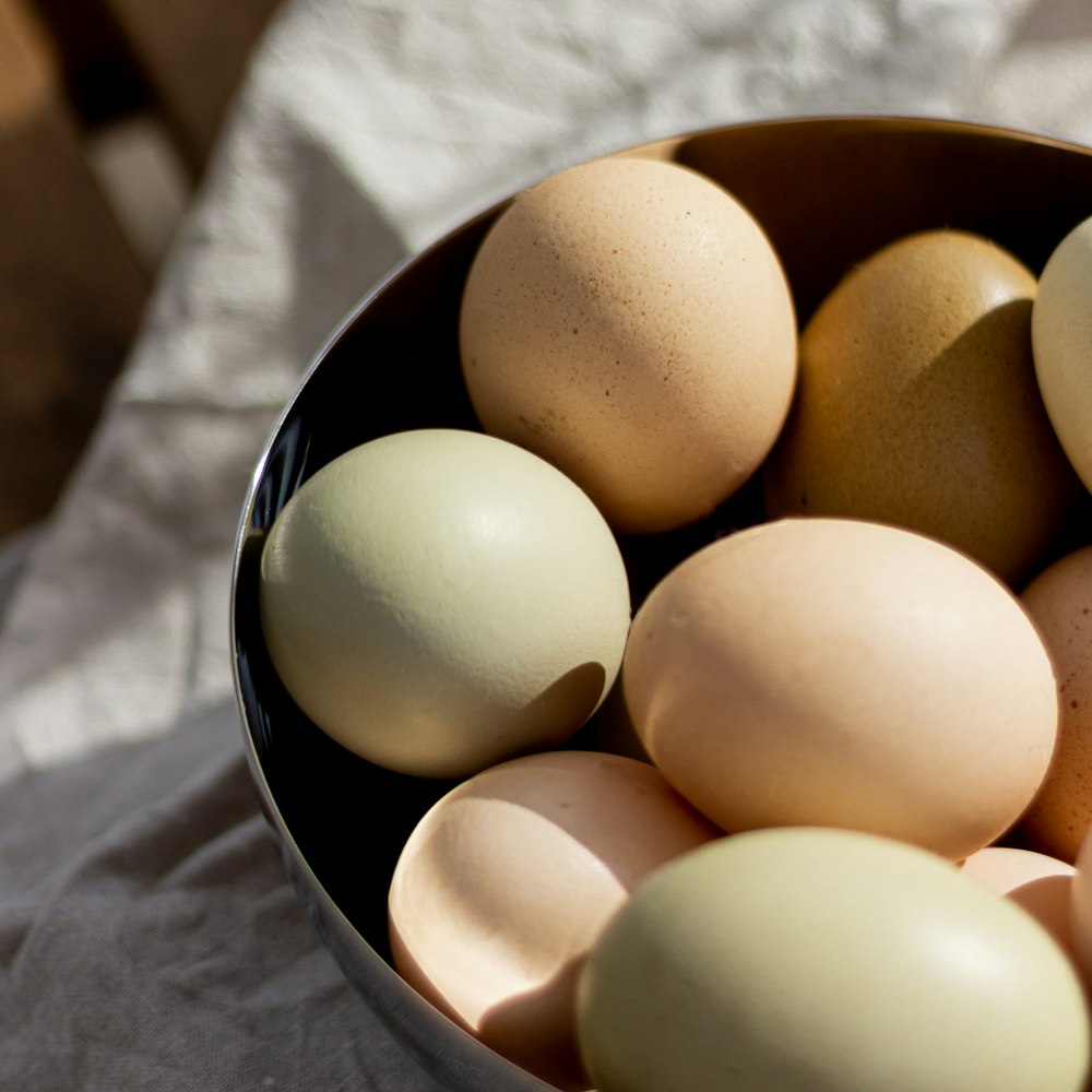 a bowl filled with eggs on top of a table