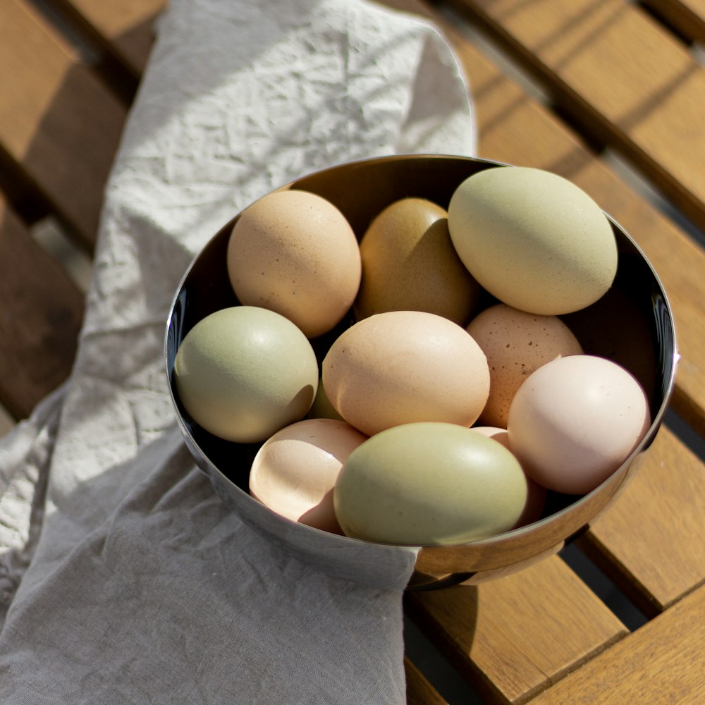 uma tigela de ovos sentada em cima de uma mesa de madeira